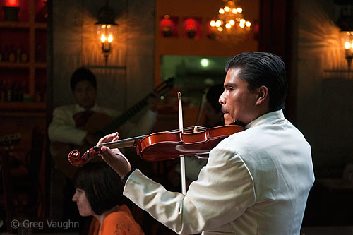 Mariachi serenading a couple in a restaurant.