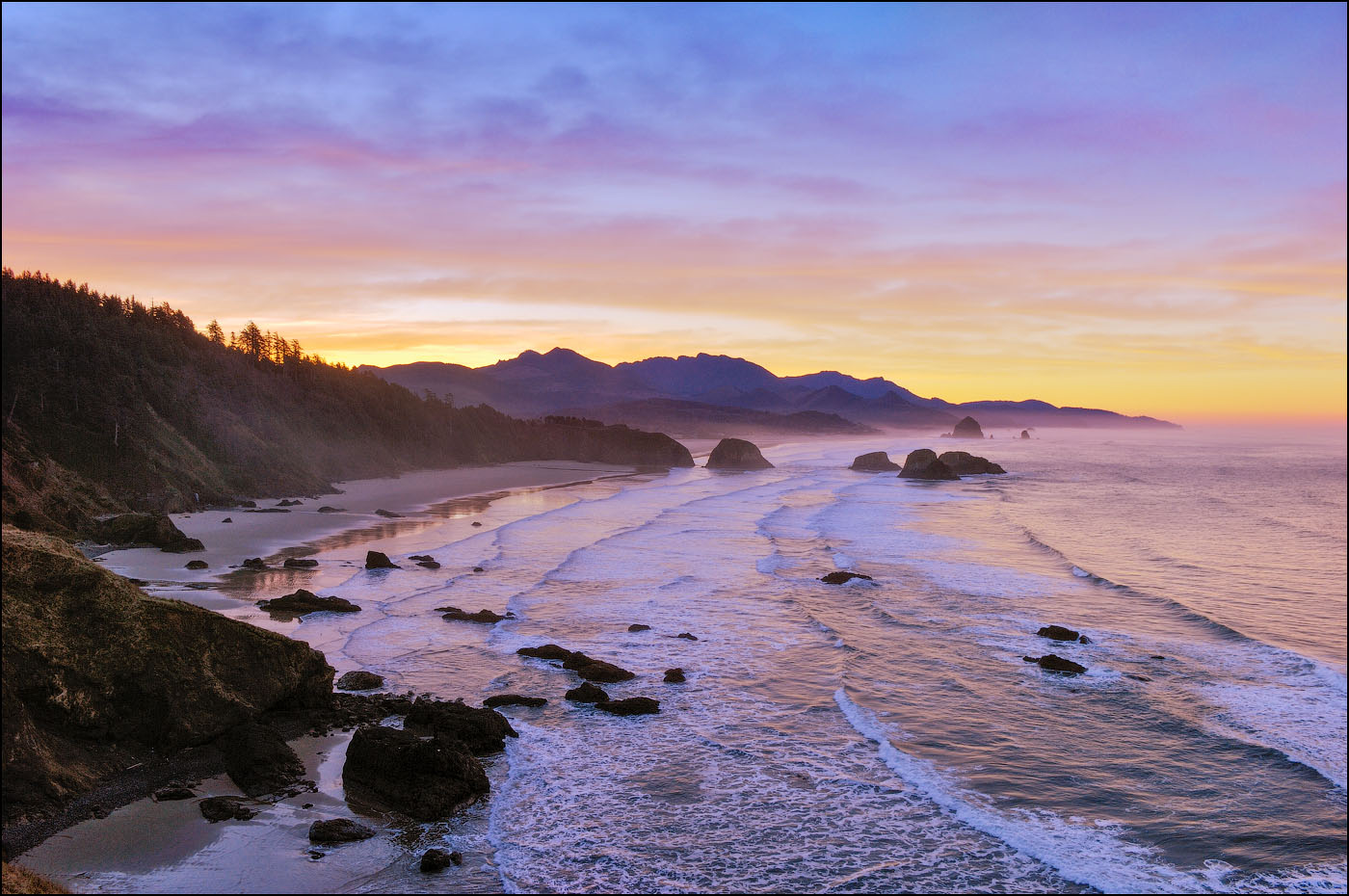 View of Crescent Beach, Cannon Beach, Haystack Rock and coast to Hug Point from Ecola State Park at sunrise; Oregon.