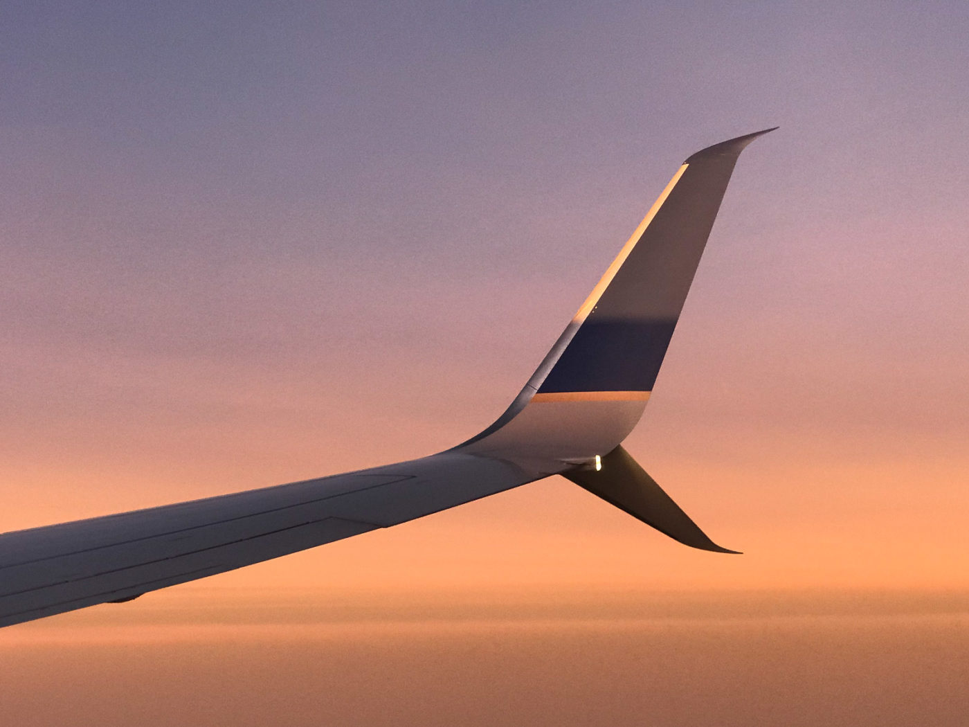 airplane wing at sunset during flight